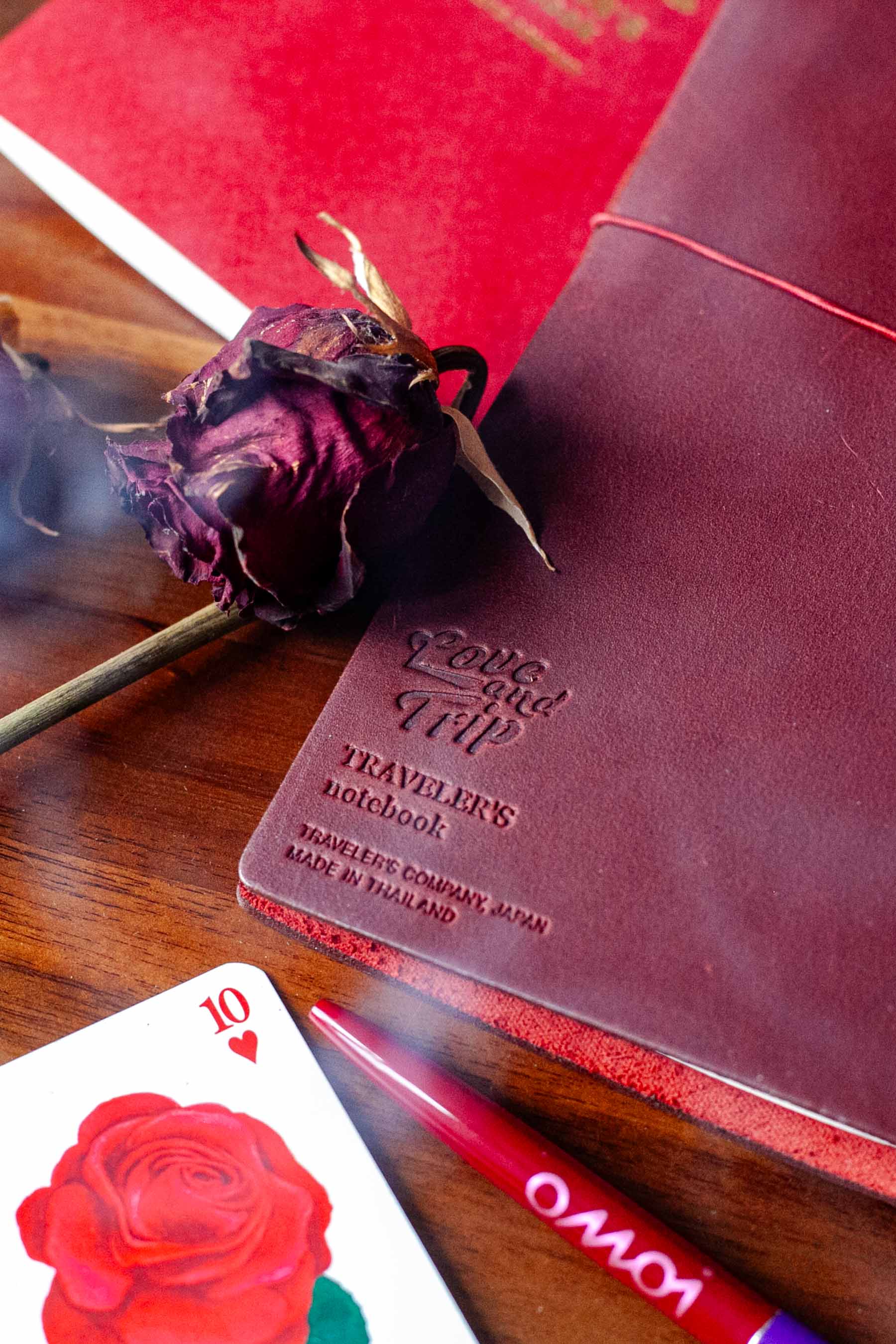 dried rose, rose playing card, with dark red leather journal cover
